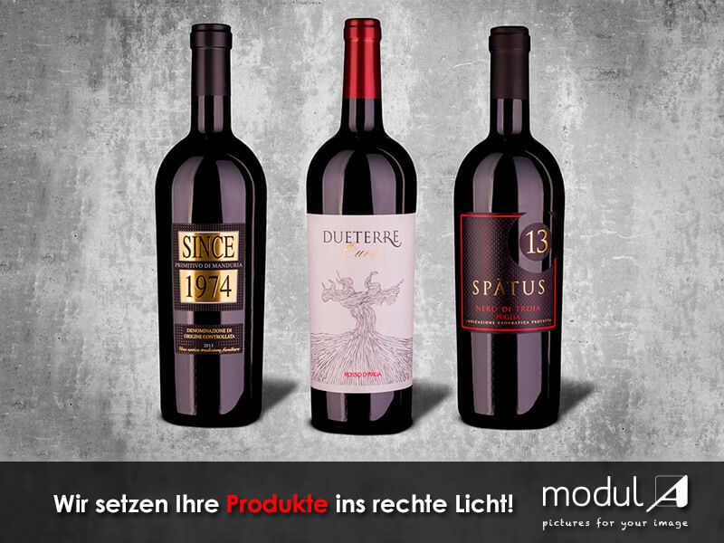 Produktaufnahme von drei Rotwein Weinflaschen auf Betonhintergrund mit natürlichem Schatten